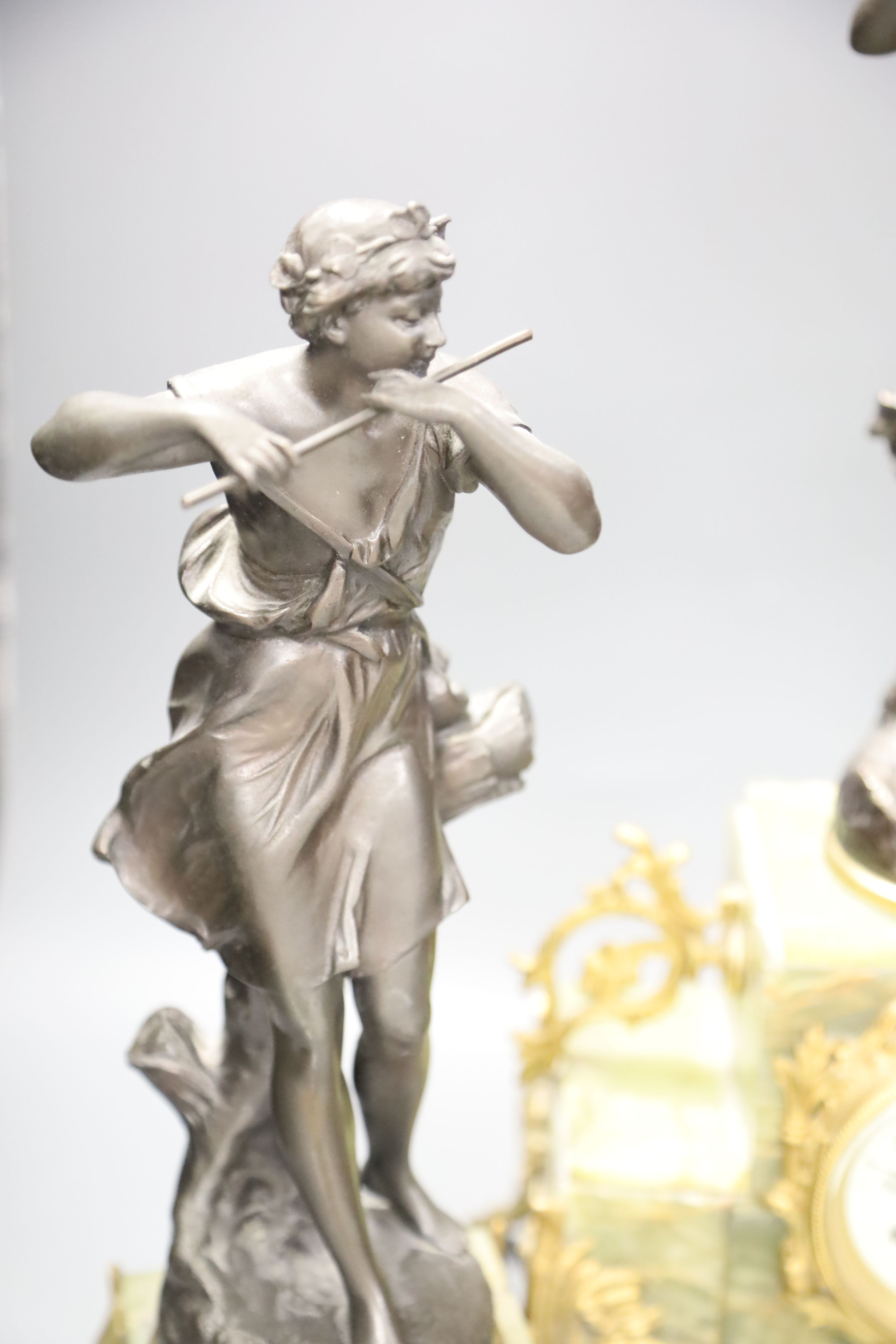 A French onyx and spelter figural clock garniture after Ferrand, plaques read Improvisateur Prisonniere and Sensitive, height 50cm